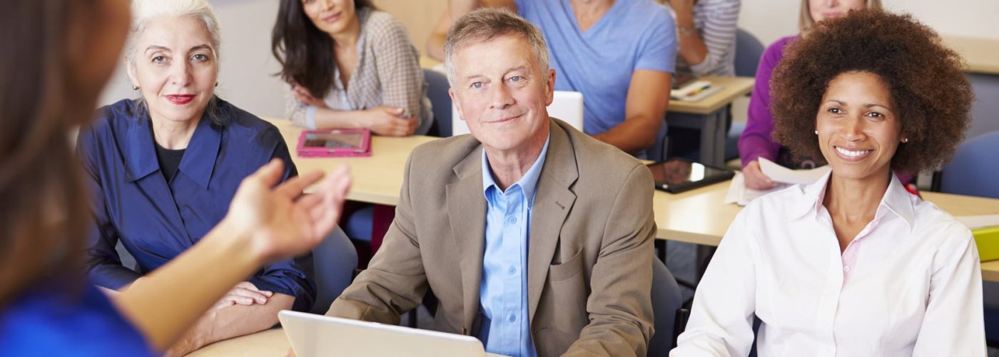 Mature Students In Further Education Class With Teacher